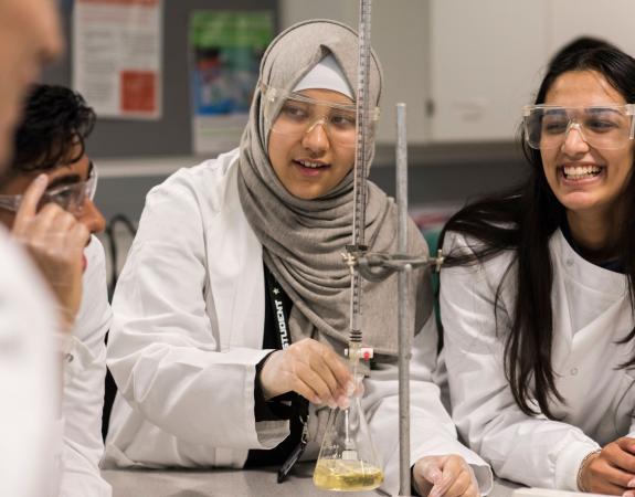 Three young students from STEM Studies College running a scientific experiment