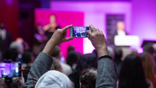 Person from the audience taking a picture at People's Question Time