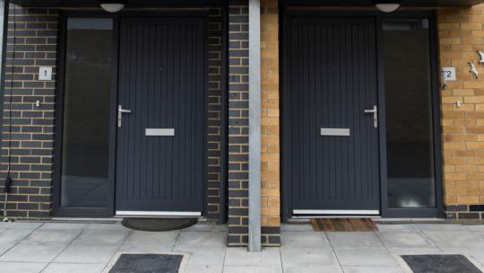 An image showing two houses with black doors