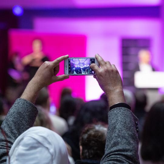Person from the audience taking a picture at People's Question Time