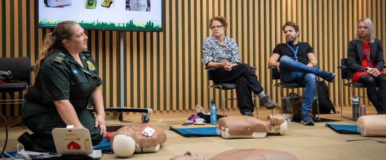 A paramedic demonstrating CPR to a classroom